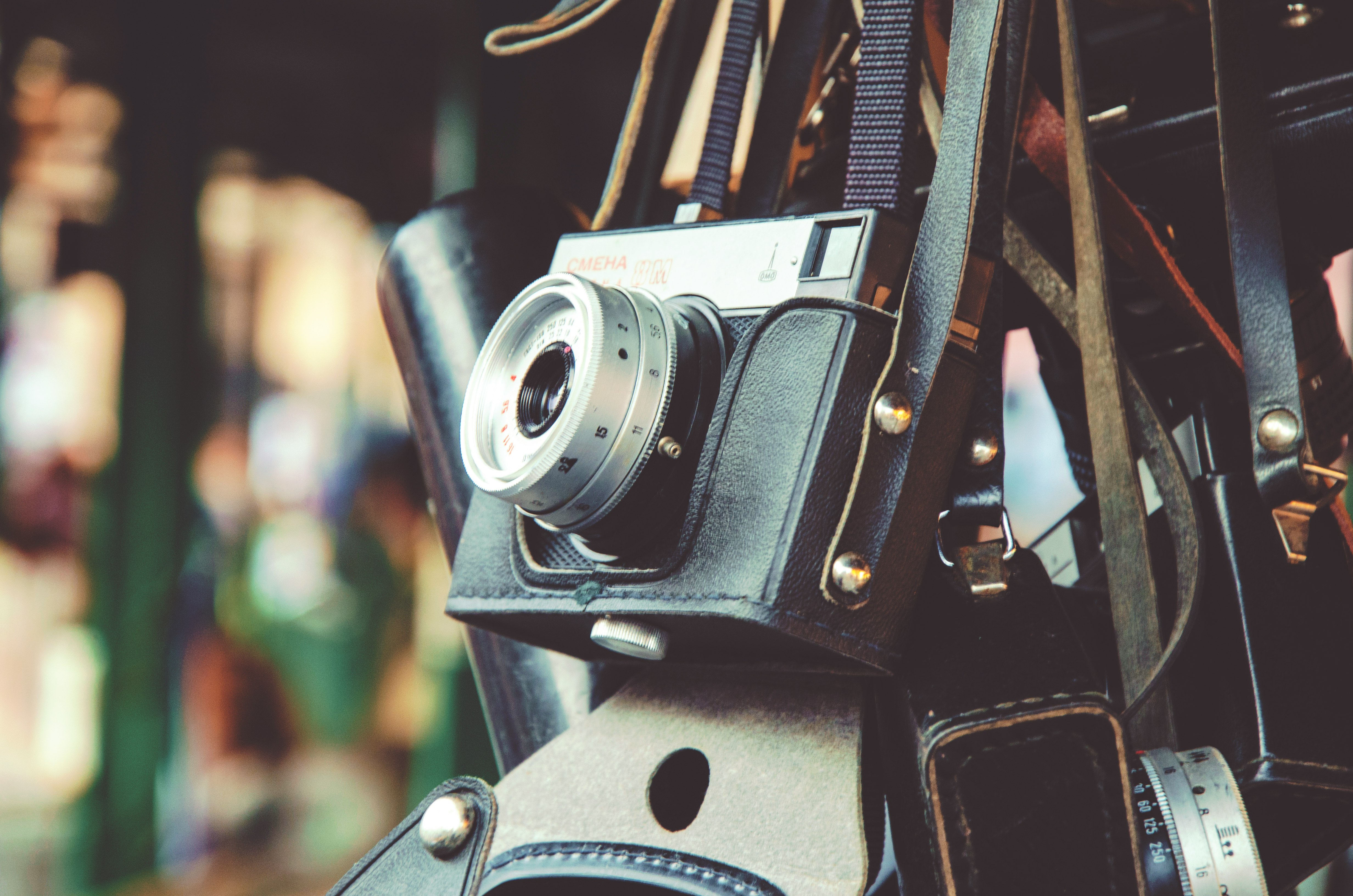 gray and black digital camera and black leather bag